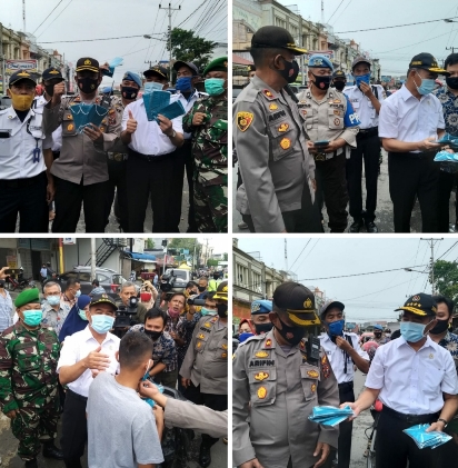 Kapolsek Medan Timur Kompol Arifin bersama Menteri Muhazir Effendi bagikan Masker