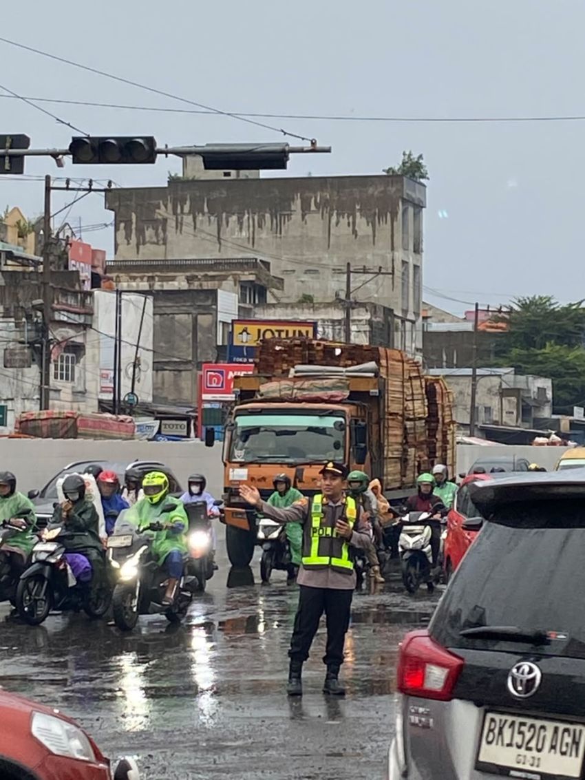 Ditengah Guyuran Hujan, Kapolsek Sunggal Atur Lalin Pagi Hari